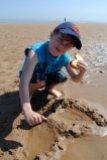 Elijah with one hand on the beach, the other on a Nutella sandwich