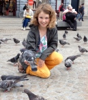 Charlotte taming pigeons in Amsterdam's central square