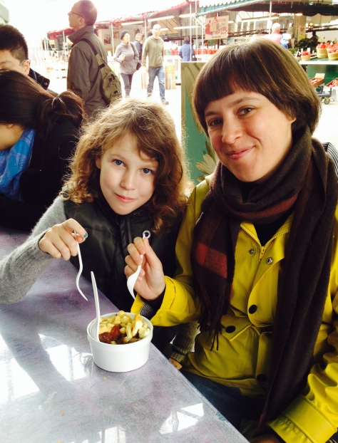 Katie and Charlotte sampling deluxe poutine at Jean Talon Market